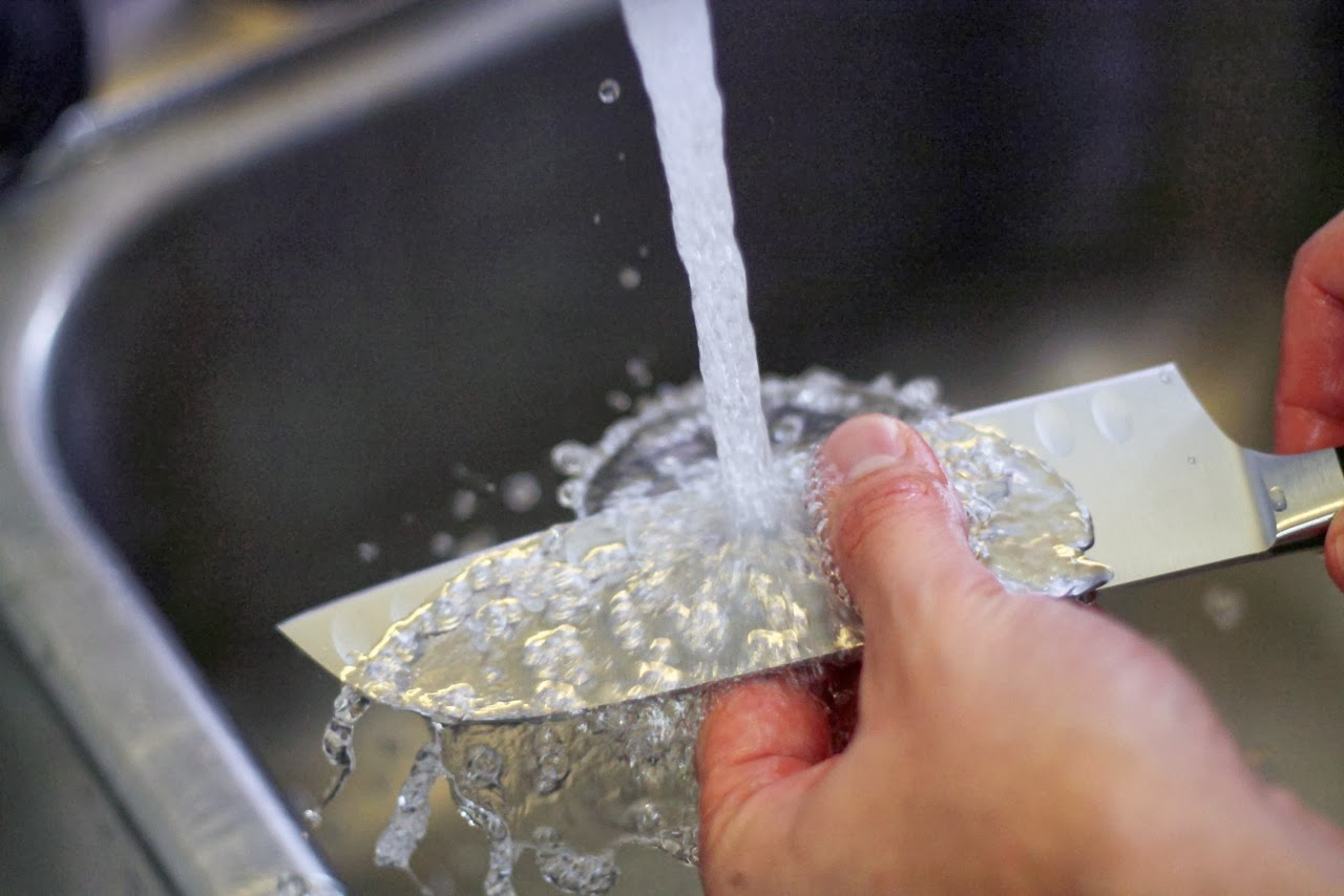 Hand wash knives with your hand and carefully scrub away food particles to prevent accidents